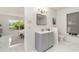 Bright bathroom with gray cabinets, a large mirror, decorative plants, and a tiled floor at 2919 Shannon Drive, Punta Gorda, FL 33950
