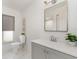 Bathroom features white cabinets, large mirror, decorative plants, and a tiled floor at 2919 Shannon Drive, Punta Gorda, FL 33950