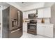 Contemporary kitchen with stainless steel appliances, marble floors, and white cabinetry for a sleek design at 2919 Shannon Drive, Punta Gorda, FL 33950