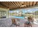Screened-in lanai overlooking the pool and canal features brick pavers and comfortable wicker seating at 2919 Shannon Drive, Punta Gorda, FL 33950