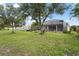 Expansive backyard features mature trees and screened-in patio, offering a private outdoor space for relaxation at 2920 Oriole Dr, Sarasota, FL 34243