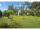 Lush green backyard with mature trees and landscaping provides privacy and a serene outdoor setting at 2920 Oriole Dr, Sarasota, FL 34243