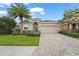 Charming single-story home featuring a lush green lawn, beautiful landscaping, and a paver driveway at 2920 Oriole Dr, Sarasota, FL 34243