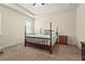 Cozy bedroom featuring a tray ceiling, a four-poster bed, and soft carpeting at 2920 Oriole Dr, Sarasota, FL 34243