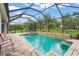 Screened-in pool area featuring a sparkling pool, a hot tub, and manicured landscaping at 2920 Oriole Dr, Sarasota, FL 34243