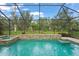 Stunning screened-in pool and spa feature a decorative tiled water feature and lush landscaping at 2920 Oriole Dr, Sarasota, FL 34243