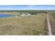 Expansive aerial view of the property featuring a large pasture, lake and grazing cattle at 29527 Leah Rd, Punta Gorda, FL 33982