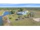 Beautiful aerial view of the house, surrounded by lush greenery, a pond, and a wooden perimeter fence at 29527 Leah Rd, Punta Gorda, FL 33982