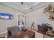 A well-lit home office featuring a dark wood desk, decorative trim, and a mounted television at 29527 Leah Rd, Punta Gorda, FL 33982