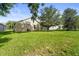 Spacious backyard featuring green grass, mature trees, and the exterior of the home at 3362 Howell Pl, Sarasota, FL 34232