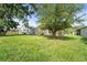 Large backyard with lush green grass and mature shade trees at 3362 Howell Pl, Sarasota, FL 34232