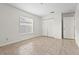 This bedroom features neutral tile flooring, a window, and double closet doors at 3362 Howell Pl, Sarasota, FL 34232