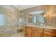 Modern bathroom with glass shower, tiled walls, stone vanity top, and wood cabinets at 350 Golden Gate Pt # 61, Sarasota, FL 34236