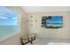 Bright bedroom features a table, water view window, and large screen TV at 350 Golden Gate Pt # 61, Sarasota, FL 34236