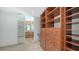 Spacious walk-in closet with wood shelves and drawers leading to the bathroom at 350 Golden Gate Pt # 61, Sarasota, FL 34236