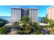 Beautiful building featuring lush tropical landscaping, a circular drive, and ample parking at 350 Golden Gate Pt # 61, Sarasota, FL 34236