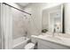 This bright bathroom features a bathtub and shower combo with white marble style tile and a vanity with white countertop at 3621 Wild Blossom Pl, Parrish, FL 34219