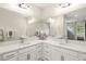This double sink bathroom features white cabinets, marble countertops and a large mirror at 3621 Wild Blossom Pl, Parrish, FL 34219