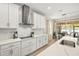 Modern kitchen with white cabinets, stainless steel range hood, and a breakfast bar at 3621 Wild Blossom Pl, Parrish, FL 34219