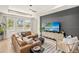 Inviting living room featuring a stylish accent wall, plush seating, and plenty of natural light at 3621 Wild Blossom Pl, Parrish, FL 34219