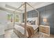 Serene main bedroom featuring a four-poster bed, stylish accent wall, and bright windows at 3621 Wild Blossom Pl, Parrish, FL 34219