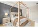 Beautifully staged main bedroom with a four-poster bed, accent wall, and elegant decor at 3621 Wild Blossom Pl, Parrish, FL 34219