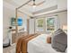 Bright main bedroom showcasing a four-poster bed, ample natural light, and modern furnishings at 3621 Wild Blossom Pl, Parrish, FL 34219