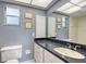 A well lit bathroom with a dark countertop vanity and bright wallpaper at 3641 Somerville Dr # 1506, Sarasota, FL 34232