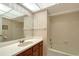 A well lit bathroom with wood vanity and shower with tub at 3641 Somerville Dr # 1506, Sarasota, FL 34232