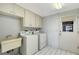 Bright laundry room features a utility sink, cabinetry, and washer and dryer at 3641 Somerville Dr # 1506, Sarasota, FL 34232