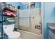 Bathroom showcasing a bathtub with sliding doors and showerhead, a toilet, and shelving for storage at 4145 W Price Blvd, North Port, FL 34286