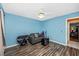 Cozy bedroom featuring wood floors, ceiling fan, and bright blue walls at 4145 W Price Blvd, North Port, FL 34286