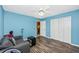 Blue bedroom with a ceiling fan, wood floors, and a closet at 4145 W Price Blvd, North Port, FL 34286