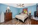 Well-lit bedroom boasting a ceiling fan, wood-look flooring, and furnishings including a dresser and nightstands at 4145 W Price Blvd, North Port, FL 34286
