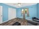 Bedroom featuring wood flooring, blue walls, a window, and a double door closet at 4145 W Price Blvd, North Port, FL 34286