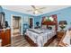 Cozy bedroom features a ceiling fan, wood floors, and a view to a walk-in closet and an ensuite bathroom at 4145 W Price Blvd, North Port, FL 34286