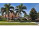 Landscaped exterior view of the clubhouse with palm trees and well-manicured lawns at 4200 Reflections Pkwy, Sarasota, FL 34233