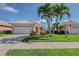 Beautiful home featuring a well-manicured lawn, vibrant landscaping, and attached two-car garage at 4200 Reflections Pkwy, Sarasota, FL 34233