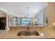 Granite countertop with a stainless steel sink overlooking the living area and beautiful lake view at 4200 Reflections Pkwy, Sarasota, FL 34233