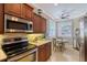 Bright kitchen with stainless steel appliances, granite counters, and a cozy breakfast nook with shuttered windows at 4200 Reflections Pkwy, Sarasota, FL 34233