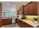 Stylish kitchen with stainless appliances, stone backsplash, granite counters and an adjacent living area with a water view at 4200 Reflections Pkwy, Sarasota, FL 34233