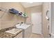 Well-lit laundry room with washer, dryer, utility sink, and ample shelving for storage at 4200 Reflections Pkwy, Sarasota, FL 34233