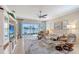 Bright living room features a ceiling fan and large sliding glass doors with lake views at 4200 Reflections Pkwy, Sarasota, FL 34233