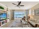 Living room with ceiling fan and access to screened patio with view of lake at 4200 Reflections Pkwy, Sarasota, FL 34233