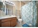 Clean bathroom with a shower featuring a patterned curtain, wood vanity, and neutral walls at 4235 Overture Cir # 4235, Bradenton, FL 34209