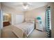 Cozy bedroom featuring a comfortable bed, a ceiling fan, and a view into a bathroom at 4235 Overture Cir # 4235, Bradenton, FL 34209