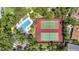 Aerial view featuring a pool, hot tub, and tennis courts with lush landscaping at 4333 Trails Dr # 10-1, Sarasota, FL 34232