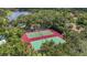 Aerial view featuring tennis courts surrounded by lush trees and a lake nearby at 4333 Trails Dr # 10-1, Sarasota, FL 34232