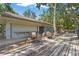 Community clubhouse with outdoor seating on a wooden patio, surrounded by lush greenery and mature trees at 4333 Trails Dr # 10-1, Sarasota, FL 34232