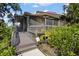Charming home featuring a screened-in deck with wooden stairs and lush, mature landscaping at 4333 Trails Dr # 10-1, Sarasota, FL 34232
